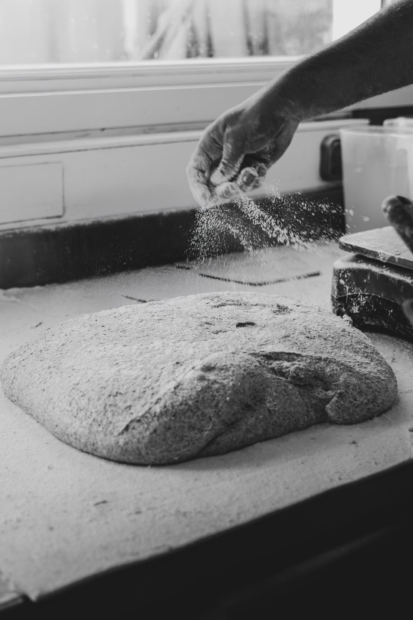 Main farinant une pâte au levain